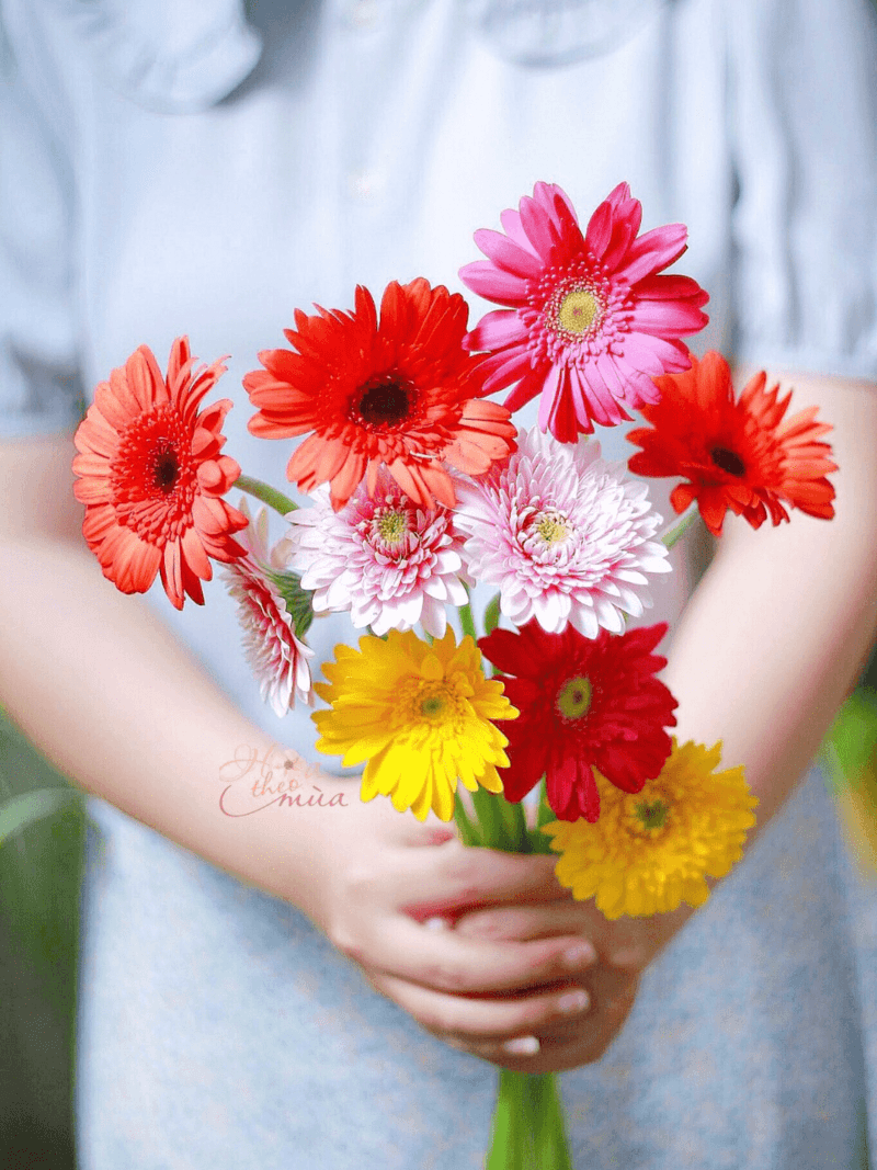 Bó hoa sinh nhật rực rỡ với hoa hồng đỏ, hoa đồng tiền cam và lá xanh